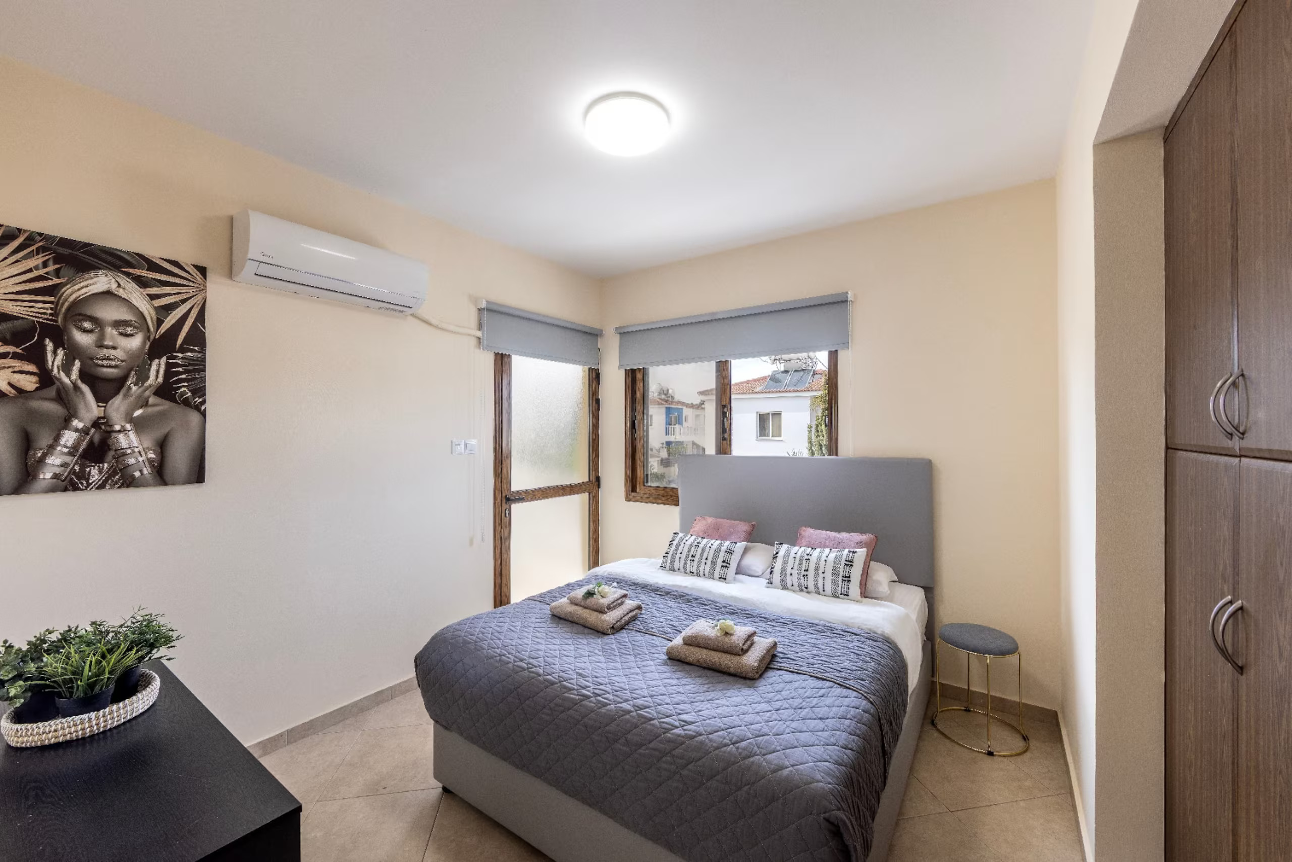 Upstairs double bedroom with grey headboard, dressing table and balcony door