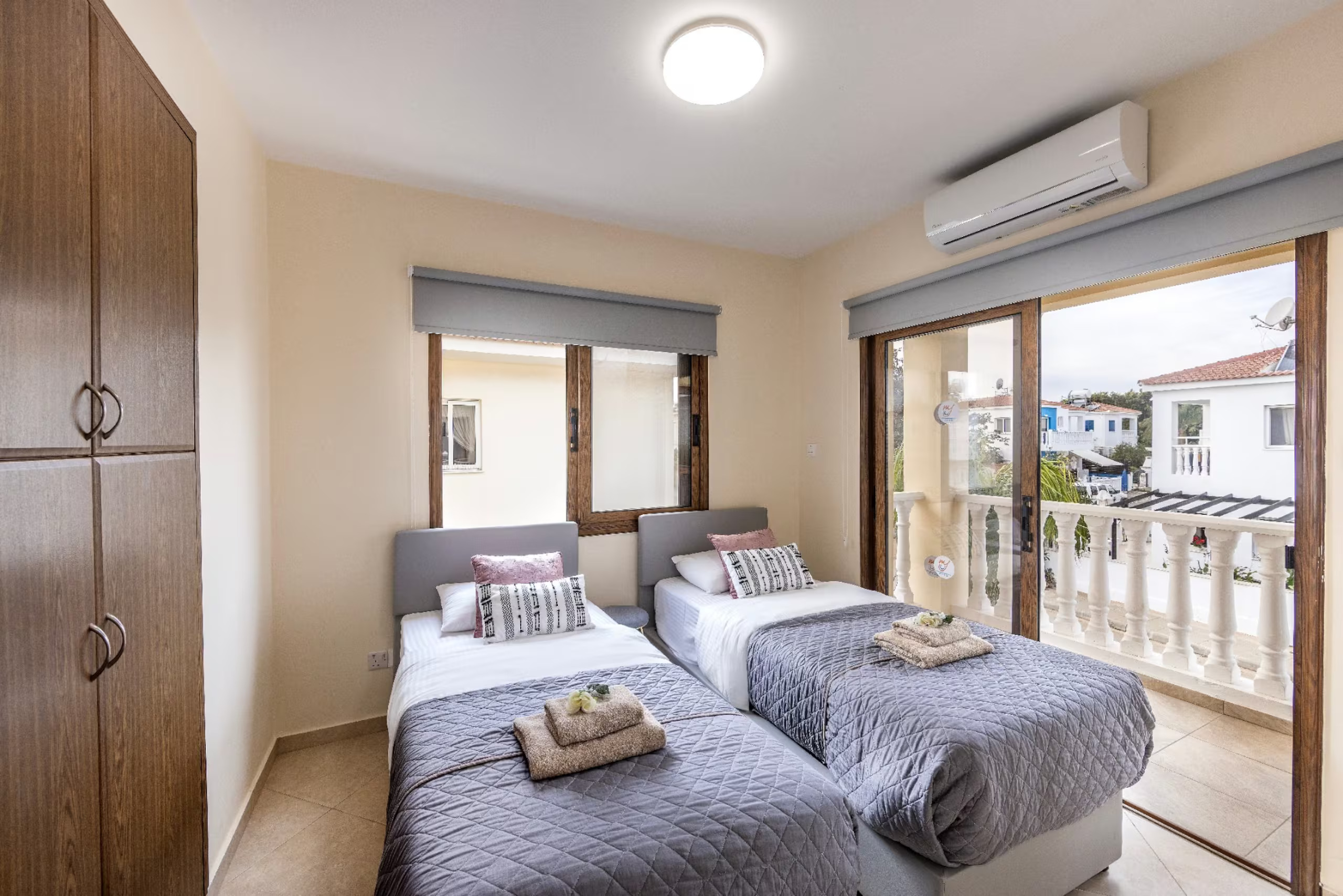 Two single beds beside the balcony doors in Villa Poseidon's twin bedroom
