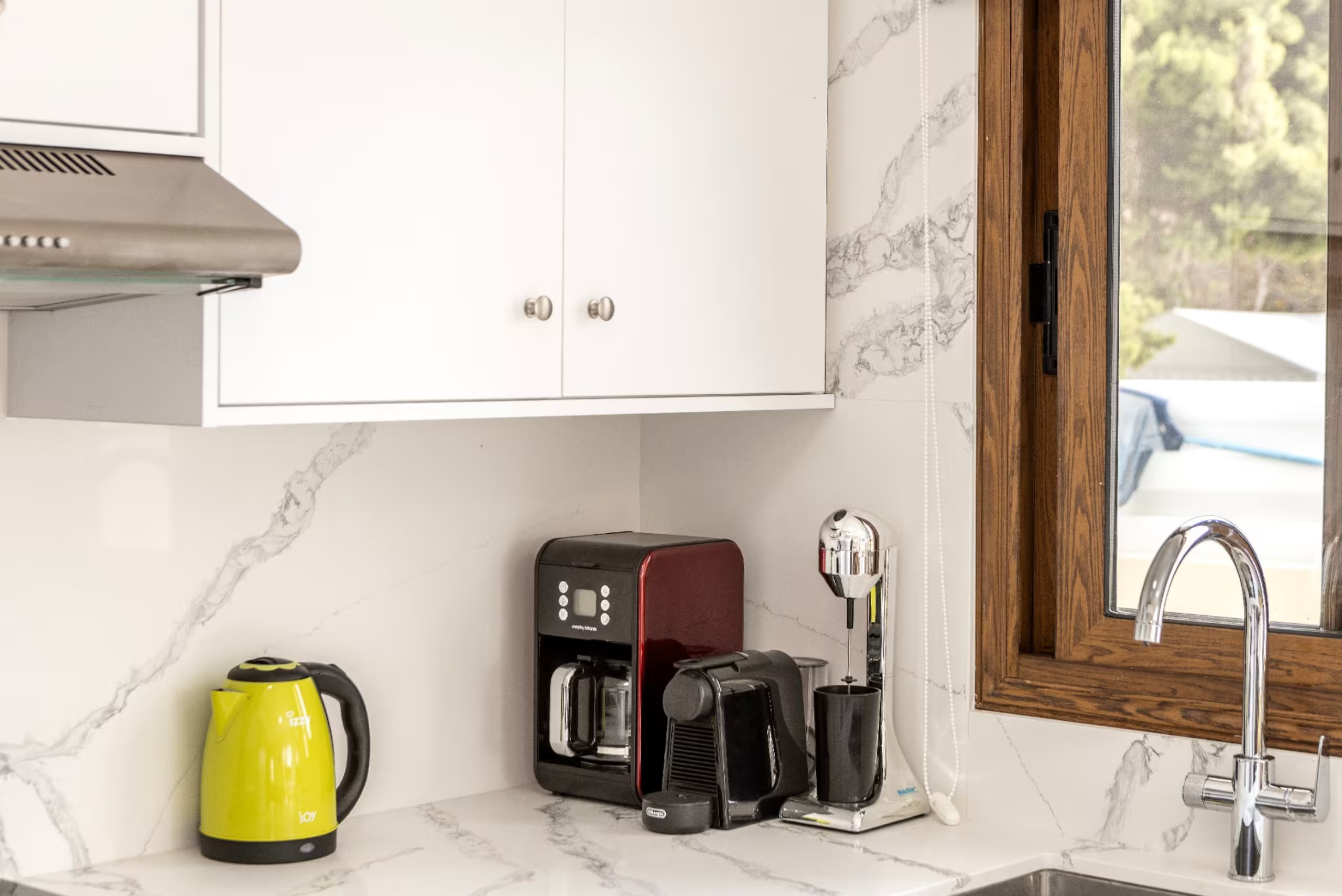 Coffee machines and kettle beside the kitchen sink at Villa Poseidon