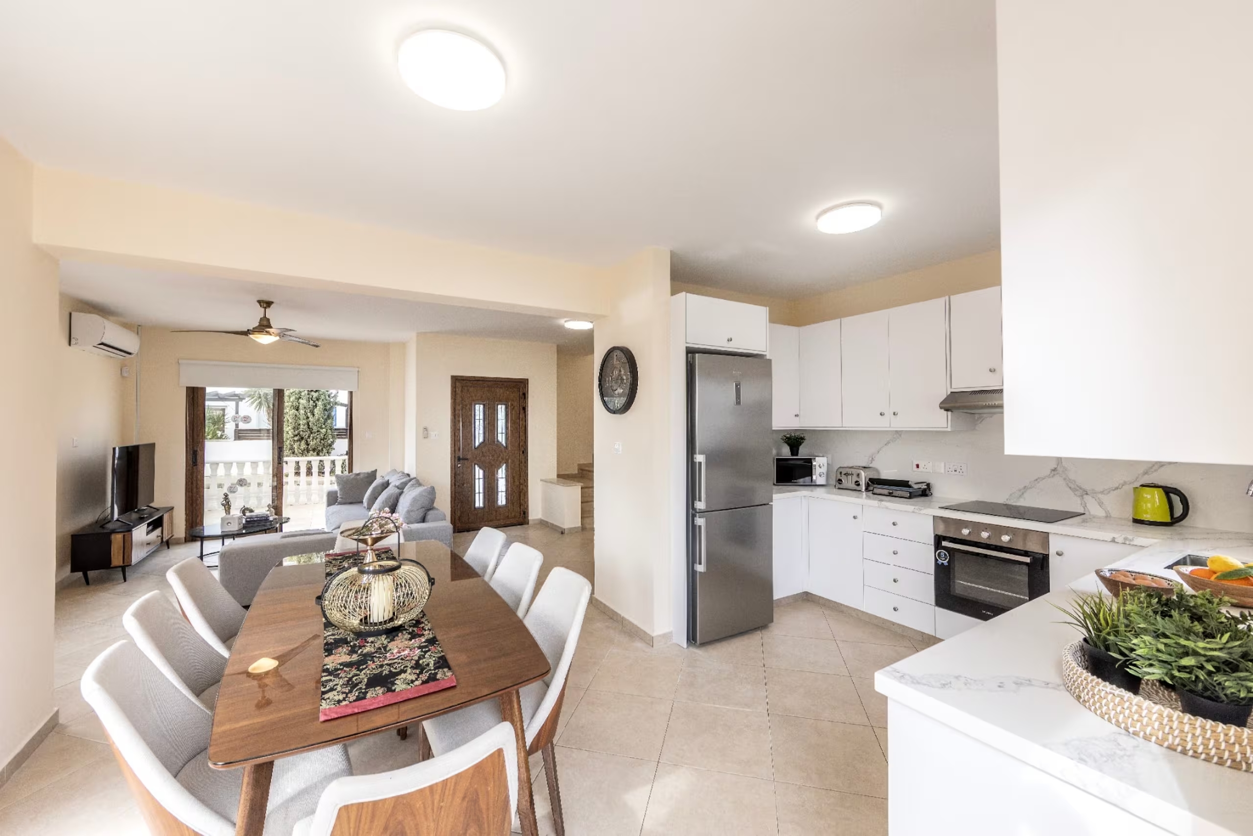 Villa Poseidon's open-plan ground floor with sofa, dining table and white kitchen
