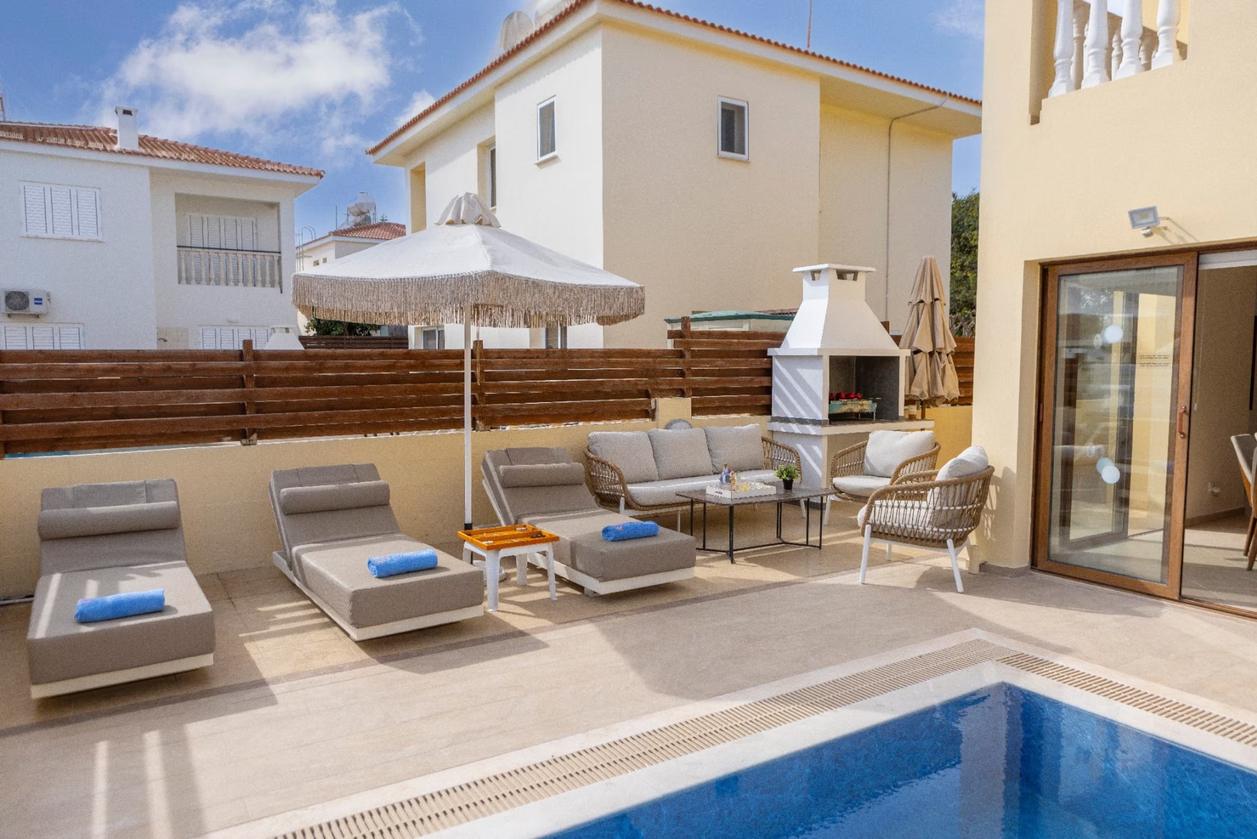 Poolside sunbeds and outdoor lounge beside the built-in barbecue