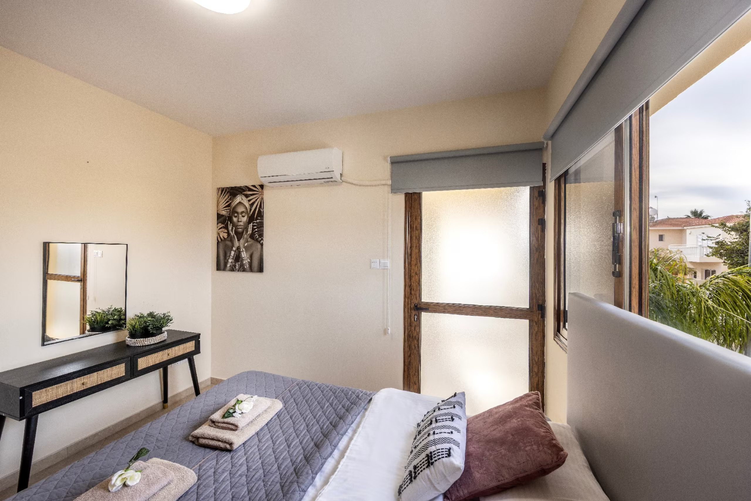 View across the master double bed towards the dressing table and balcony doors